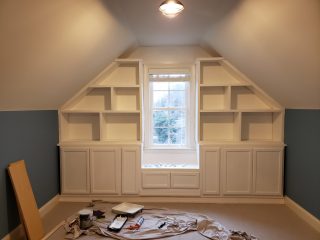 Custom built-in cabinets and shelving fitted around a window