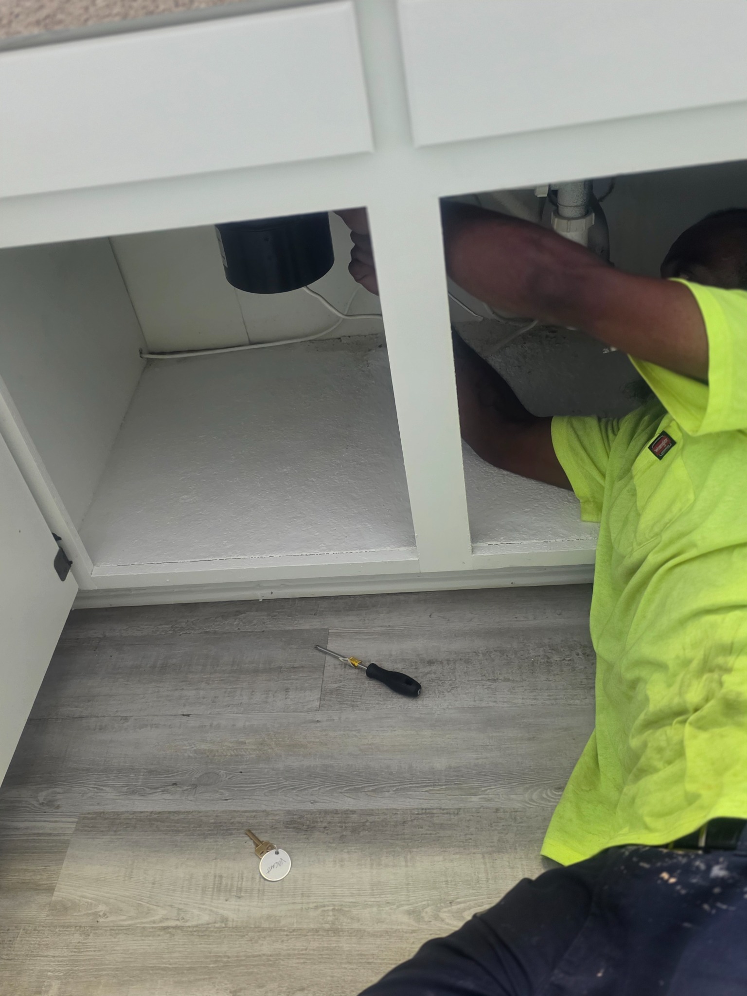 Gotta Love That Handyman installing a garbage disposal beneath a kitchen sink